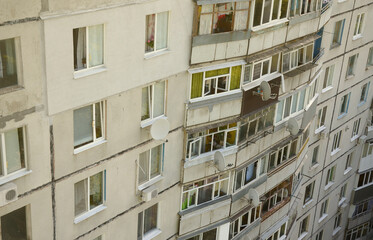 Facade of a grey multi storey soviet panel building. Russian old urban residential houses with windows and balcony. Typical russian neighborhood