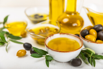 Olive oil in a bottle on a white texture background. Oil bottle with branches and fruits of olives. Place for text. copy space. cooking oil and salad dressing.