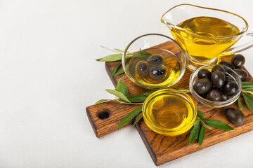 Olive oil in a bottle on a white texture background. Oil bottle with branches and fruits of olives....