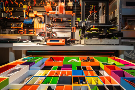 Drawer with colorful compartments for parts. Home workshop. Wall with tools. 3d printers. - Powered by Adobe