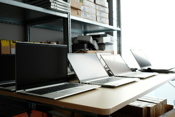Row of laptops being prepared and set up for new employees in a company