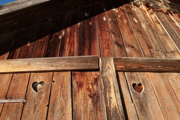 Wooden front of a barn hut shed shelter with heart shaped holes, Allgau, Germany