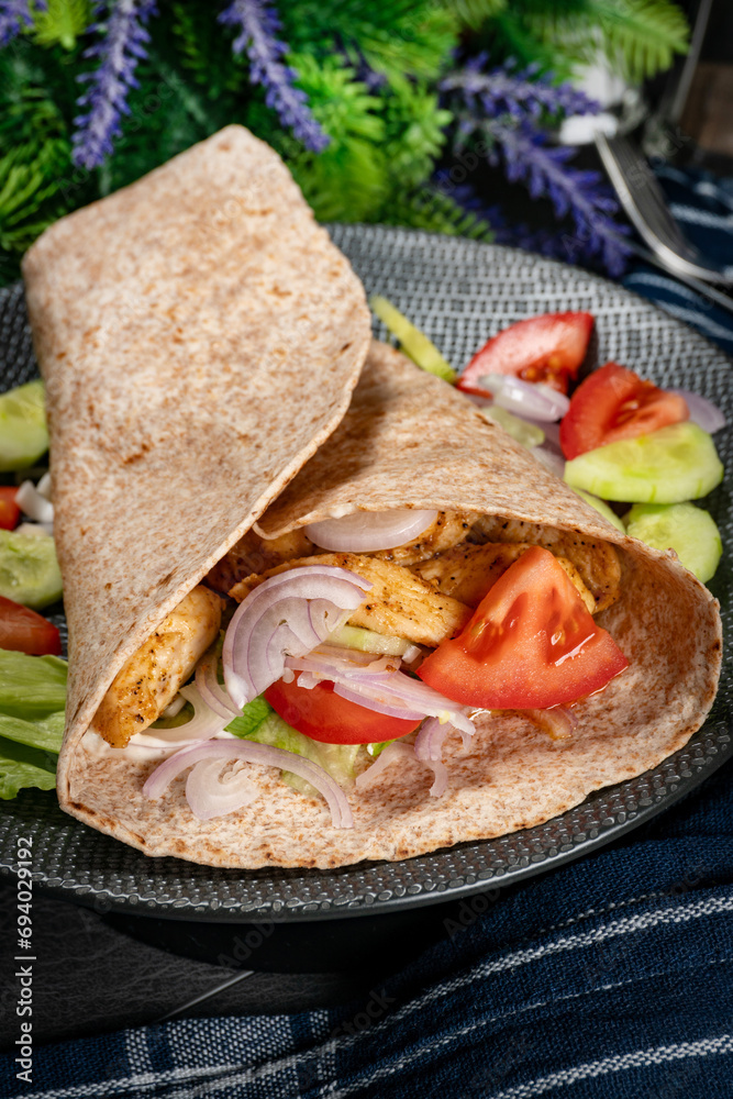 Canvas Prints Wholegrain tortilla wraps with vegetables and chicken on a plate.