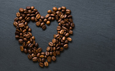 a heart from coffee beans on grey background 