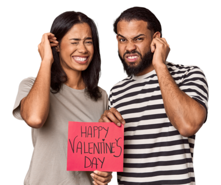 Latina couple with Valentine's sign covering ears with hands.