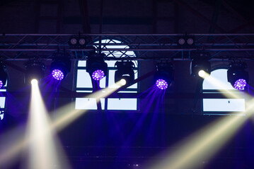 concert stage. bright colorful lighting beams on dark background