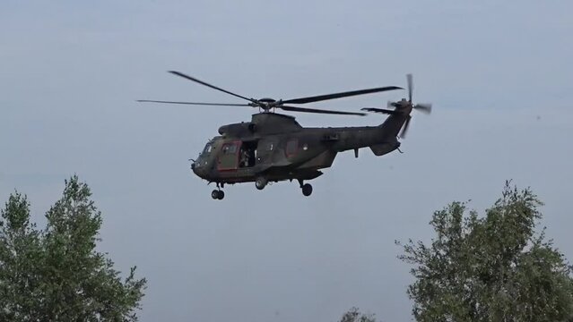 Military helicopter Hovering between trees