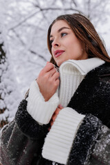 Winter holiday travel, Christmas day, New Year, beautiful happy woman portrait at snowy forest, nature woods, ski resort, leisure activity outdoors, Young Lady enjoying snow flakes fall, sweater