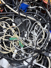 jumble of computer wires and cables  on wooden floor