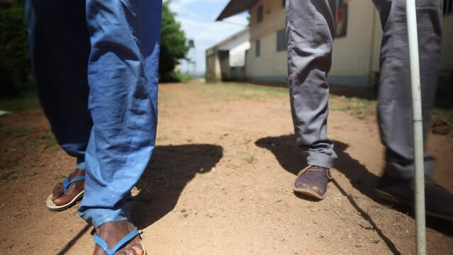 Close-up of the legs of two blind people walking using cane