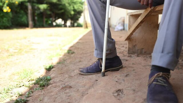 Close-up of a blind person's feet holding a cane for the blind