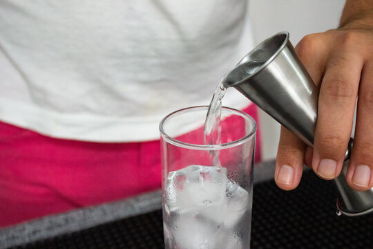 Bartender putting vodca in a drink