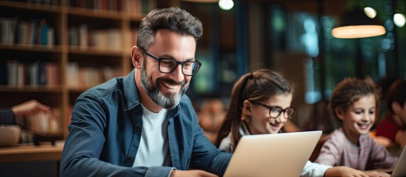 Male tutor teaches children digital literacy and coding in elementary school, using modern technology.