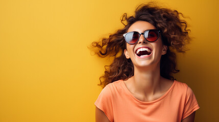 Young woman laughing happily while wearing sunglasses. Photo, copy space