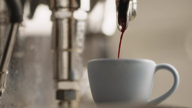 Slow motion espresso pour from single spout portafilter in blue cup
