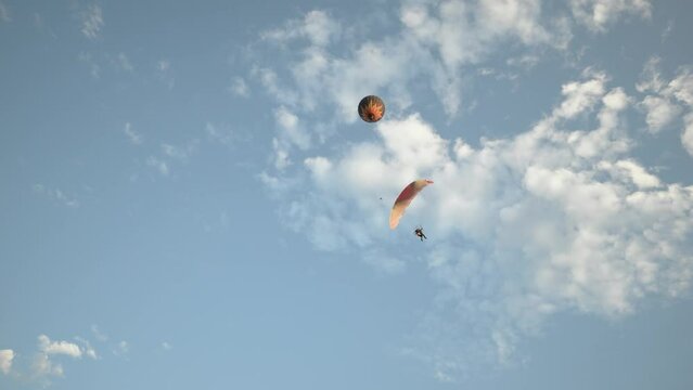 Hot air balloons and paragliders flying during a beautiful sunrise in the Serra da Canastra mountains in Minas Gerais, southeastern state of Brazil