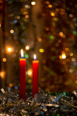 Three red candles with Christmas balls and dark background with