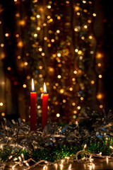 Three red candles with Christmas balls and dark background with