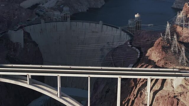 Hoover Dam on the Colorado River straddling Nevada and Arizona at dawn from above. Aerial view of Hoover Dam and the Colorado River Bridge
