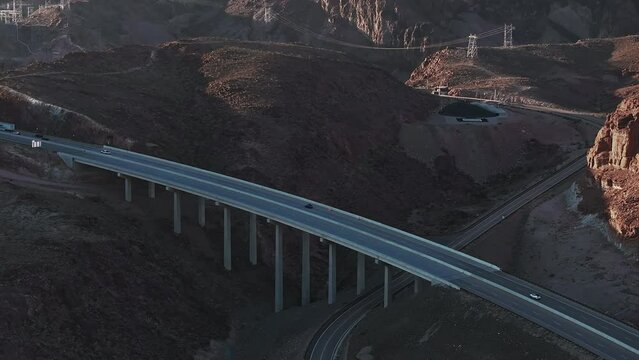 Hoover Dam on the Colorado River straddling Nevada and Arizona at dawn from above. Aerial view of Hoover Dam and the Colorado River Bridge