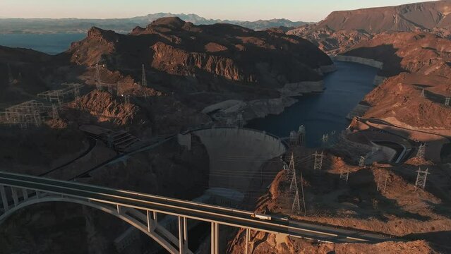Hoover Dam on the Colorado River straddling Nevada and Arizona at dawn from above. Aerial view of Hoover Dam and the Colorado River Bridge