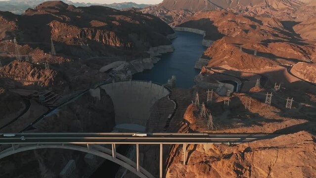 Hoover Dam on the Colorado River straddling Nevada and Arizona at dawn from above. Aerial view of Hoover Dam and the Colorado River Bridge