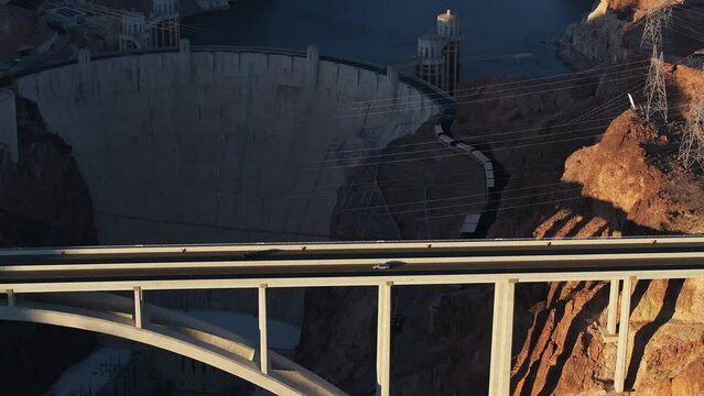 Hoover Dam on the Colorado River straddling Nevada and Arizona at dawn from above. Aerial view of Hoover Dam and the Colorado River Bridge