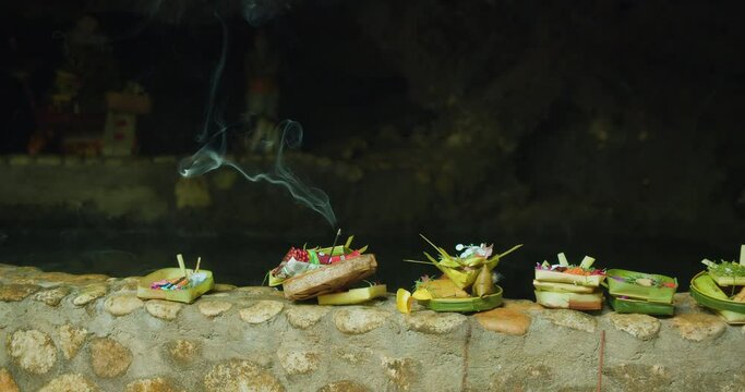 Canang Sari daily offerings made by Balinese Hindus to thank God Deva in praise and prayer. Baskets of flowers and burning incense sticks.
