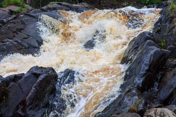 a bubbling fast cold river with cliffs and waterfalls, a mountain river with rapids