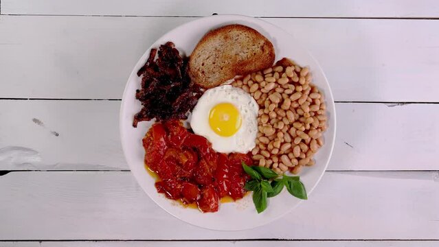 Breakfast for with fried eggs, tomato, beans.