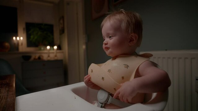 Smiling Baby Being Spoon-Fed In High Chair