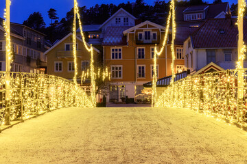 A timeless holiday scene in Norway's charming Town with festive illumination on the bridge.