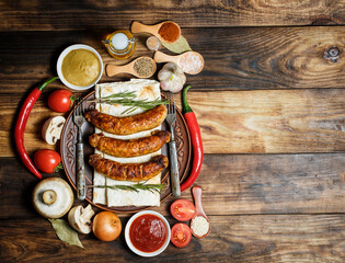 Obraz na płótnie Canvas Fried barbecue sausages with vegetables and various spices