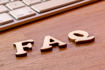 faq word or concept made by wooden letters on wooden background, frequently asked questions...