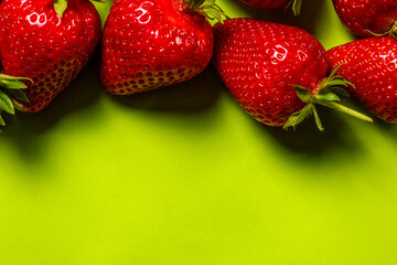 Fresh red strawberries on green background