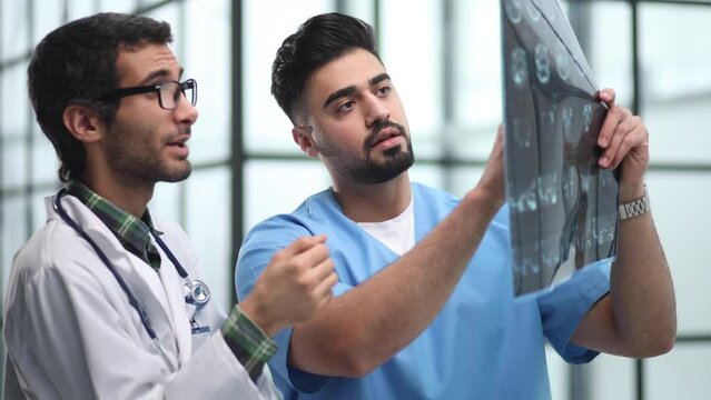 Two male doctors looking at brain x-ray