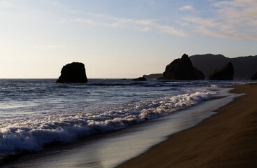 Ocean Waves On Sand Beach With Off Shore Rocks