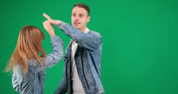dance bachata on a green background chromakey man and woman in denim clothes dance a movement Latin American dance smile spend time together entertainment hobby take care of health studio exercise