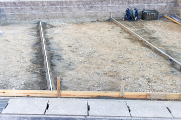 コンクリート工事のために掘削して型枠を設置した民家の庭