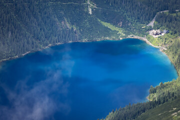 Mountain lake Morskie Oko in the Polish Tatras in summer, view from the top called Rysy. - obrazy, fototapety, plakaty
