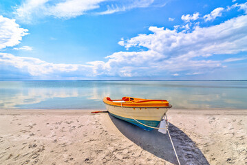Samotna łódź na plaży nad morzem oceanem