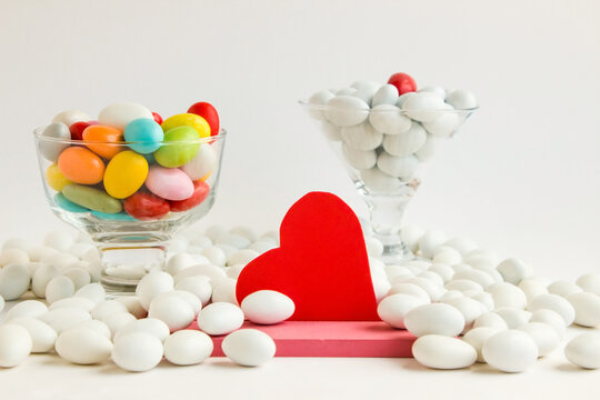 Colorful Almond Candies Bowl designed with red color blank heart with sticker on a white surface.Conceptual image