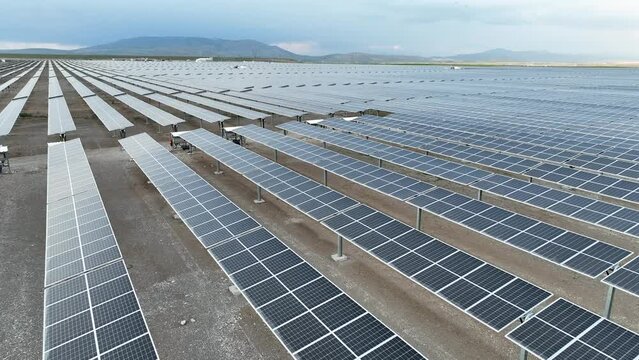 Solar panels in power station.  Flying over a solar farm with photovoltaic panels converting solar power to electricity for green energy on agricultural land
