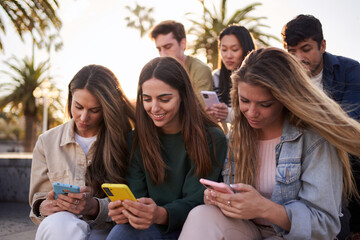 Diverse group of university friends sitting on street staircase, serious students people using and looking at smart phones. Photo shows addiction to new technologies and social networks, generation Z. - obrazy, fototapety, plakaty
