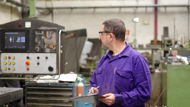 Video of an engineer controlling the proper functioning of CNC factory machinery