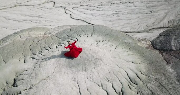 Semazen (dervish) is dancing in the traditional red dress. Whirling dervish in red traditional dress is spinning in awe.
