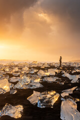 Tourists admiring the sunset in the Diamond beach, volcanic beach with icebergs, Iceland