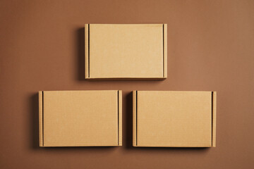 Many closed cardboard boxes on brown background, flat lay
