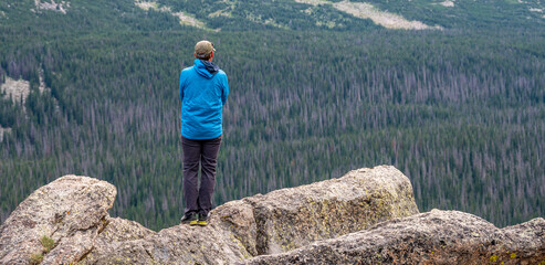 Man Overlooks Rocky Mountain Wilderness from Stormy Peaks