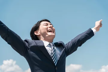 Foto op Plexiglas 青空の中で叫ぶ若いアジア人ビジネスマン（転職・勝利・就職・脱サラ・チャレンジ・頑張る・達成）  © buritora